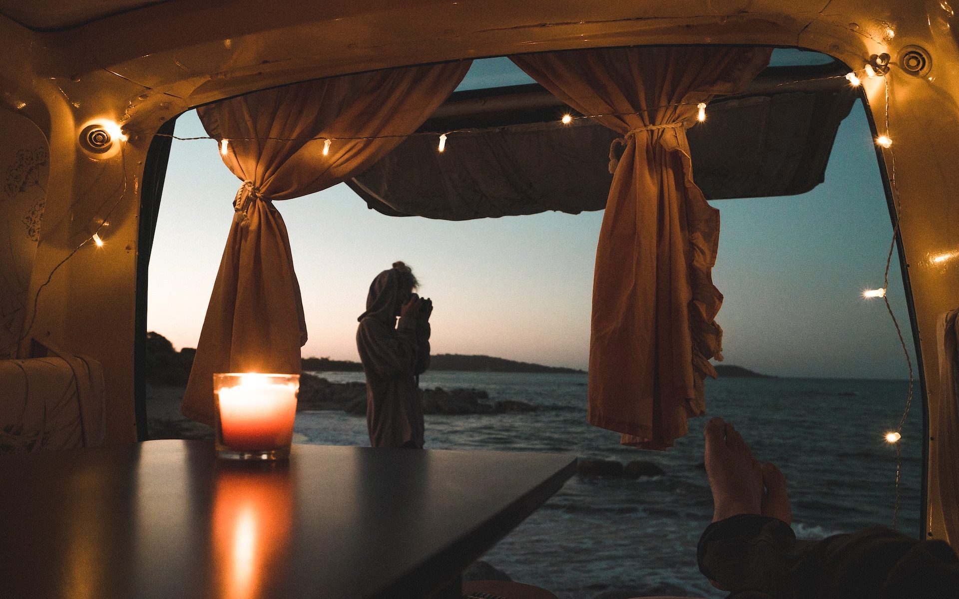 person lying on couch with body of water view at dusk